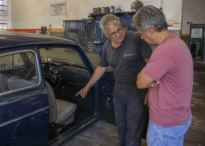mecânico avaliando câmbio de carro antigo sem desmontagem