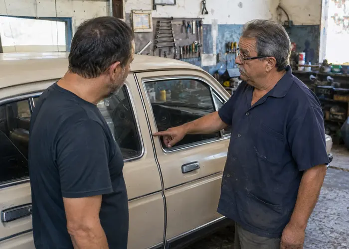 funileiro avaliando vedação de porta em carro antigo