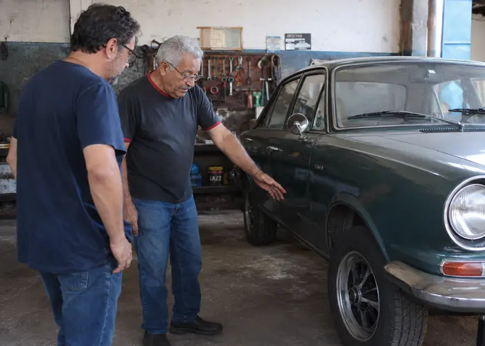 mecânico avaliando rodagem de carro antigo