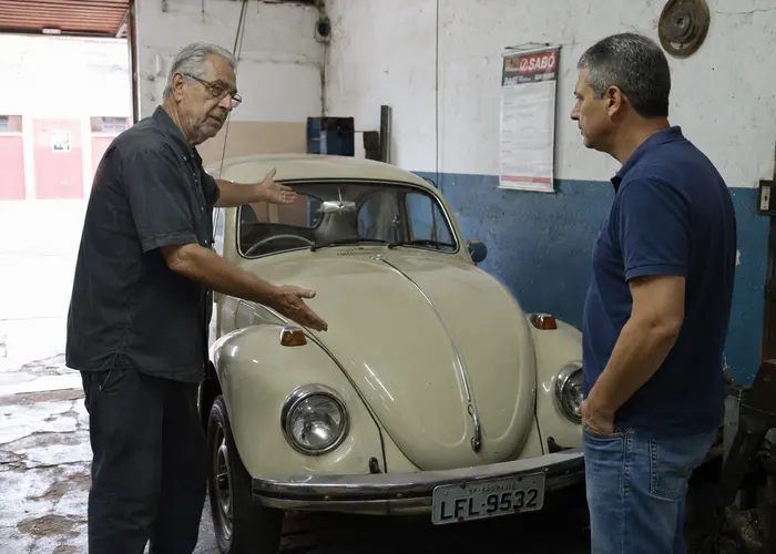 mecânico avaliando direção de carro antigo