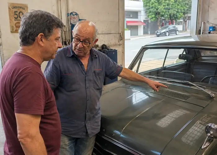 eletricista avaliando limpador de para-brisa em carro antigo